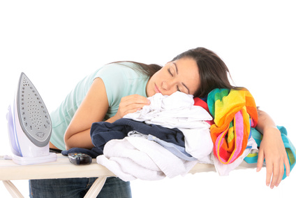 Jeune femme endormie sur une pile de linge à repasser